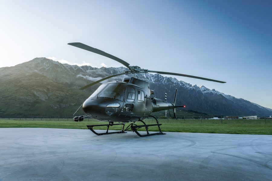 Black Airbus H125 helicopter (ZK-IHW) on the helipad at Heliworks Queenstown, featuring advanced engineering and sleek design.